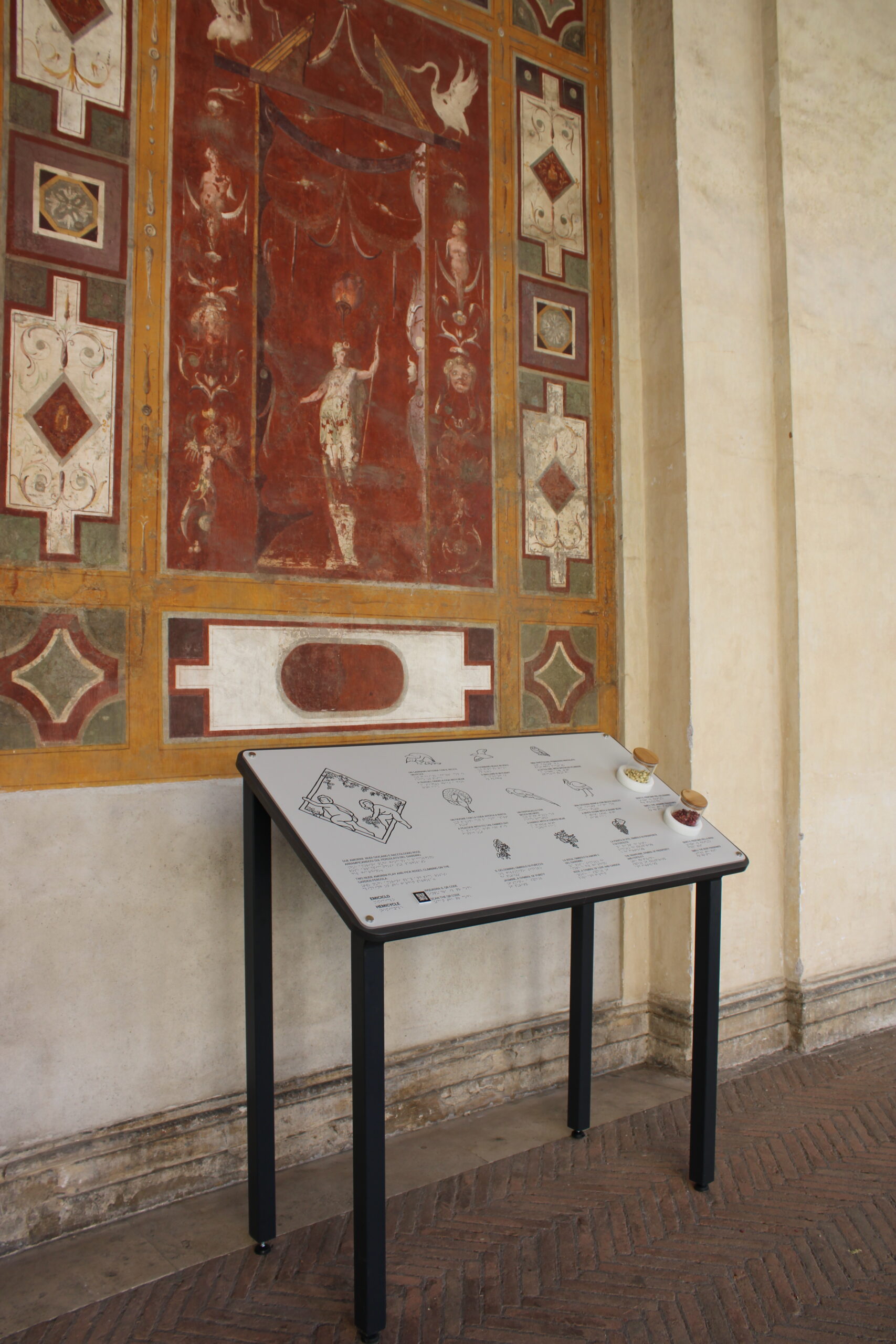 La postazione multisensoriale lungo l'emiciclo di Villa Giulia dedicata all'esplorazione olfattiva e tattile dell'affresco degli amorini, con ampolle contenenti rose e gelsomini